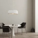 Angle view of the pendant light in a modern home decor setting, with the cord trailing down to a ceiling hook.