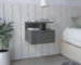 Smoke grey floating nightstand drawer with shelves mounted on wall beside bed