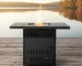 Propane fire pit table with blue flame on patio surrounded by chairs