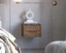 Dark brown floating nightstand with drawer mounted on wall beside bed