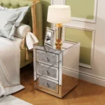 Modern crystal nightstand with drawers featuring mirrored finish and diamond details in a glamorous bedroom setting