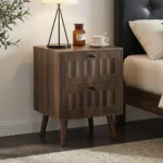 Modern double drawer nightstand with solid wood legs in walnut finish against a bedroom wall