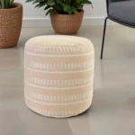 Goldoma 20 inch brown striped polyester pouf ottoman used as a footrest in a cozy living room setting
