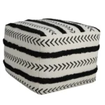 White striped storage ottoman in living room with books and decor on top
