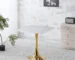 Modern square marble dining table with gold metal base in a bright dining room