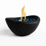 Black concrete mini tabletop fire pit with smokeless ethanol flame on a wooden table