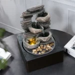 Goldoma fountain in a cozy living room setting on a wooden side table, water cascading down three tiers, ambient