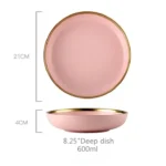 Elegant dinnerware set with gilt rim pink porcelain plates, bowls, mugs, and cutlery on a table