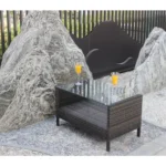 Outdoor coffee table with clear tempered glass top and brown PE rattan frame on a patio