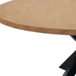 Rustic round dining table with natural acacia wood top and black iron pedestal base in a farmhouse dining room