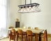 Goldoma 32-inch black and white 5-light pendant chandelier with modern metal cage design, hanging from ceiling in a