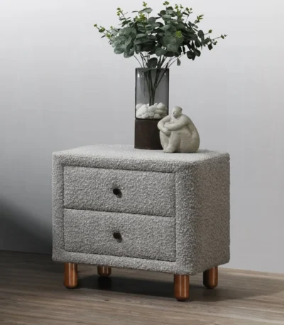 Gray boucle nightstand with two drawers and wooden legs in a modern bedroom setting