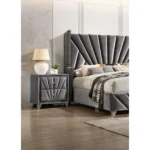 Gray fabric upholstered nightstand with chrome legs and drawers in a modern bedroom setting