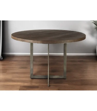 Small dining table with rustic wood top and brown gray metal sled base in a modern living room setting