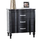 Black solid wood nightstand with curved front and turned legs in a bedroom setting