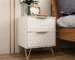 Modern nightstand with drawers, gold legs, and 3D embossed design in a bedroom setting
