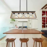 A side view of the Goldoma industrial chandelier showing the circular cage and chain suspension in a loft setting.