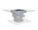 Gray wood dining table with square glass top and pedestal base in a modern dining room