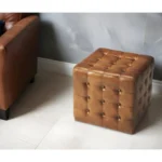 Goldoma brown tufted faux leather cube ottoman as footrest and extra seat in living room