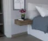 Dark brown floating nightstand with drawer mounted on wall next to bed