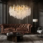 Gold crystal chandelier hanging in modern dining room with golden light reflections