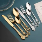 24-piece stainless steel cutlery set with gold handles displayed on a wooden table