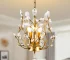 Elegant gold crystal chandelier with three lights hanging in a modern living room