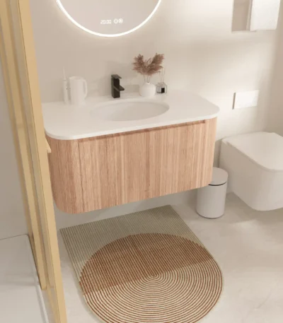Goldoma wall-mounted bathroom vanity with round basin, white finish, installed in a modern bathroom setting, front view.
