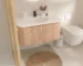 Goldoma wall-mounted bathroom vanity with round basin, white finish, installed in a modern bathroom setting, front view.