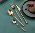 Matte black gold flatware set arranged on a table, showcasing elegant cutlery