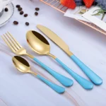 Elegant gold flatware set with fork, knife, and spoon on a white tablecloth