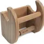 Side view of the HMS teak and stainless steel toilet paper holder on a bathroom vanity, highlighting its compact design.