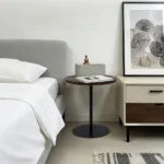 Set of two small round side tables with concentric circle walnut wood tops and black metal pedestal bases, modern design for living room or bedroom