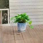 Large ceramic planter with an orchid planted inside, set on a windowsill with soft natural light, emphasizing the