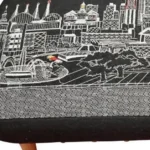 Goldoma 38-inch black wool ottoman with brown legs and nailhead trim used as a stylish footrest in a modern living room