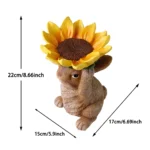 Bunny figurine in a bird bath setting, sunflower hat prominent, garden decor.