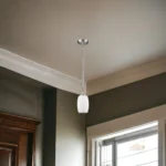 Close-up of the silver metal frame and frosted glass shade of the HMS hanging light, showing warm 3000K glow.