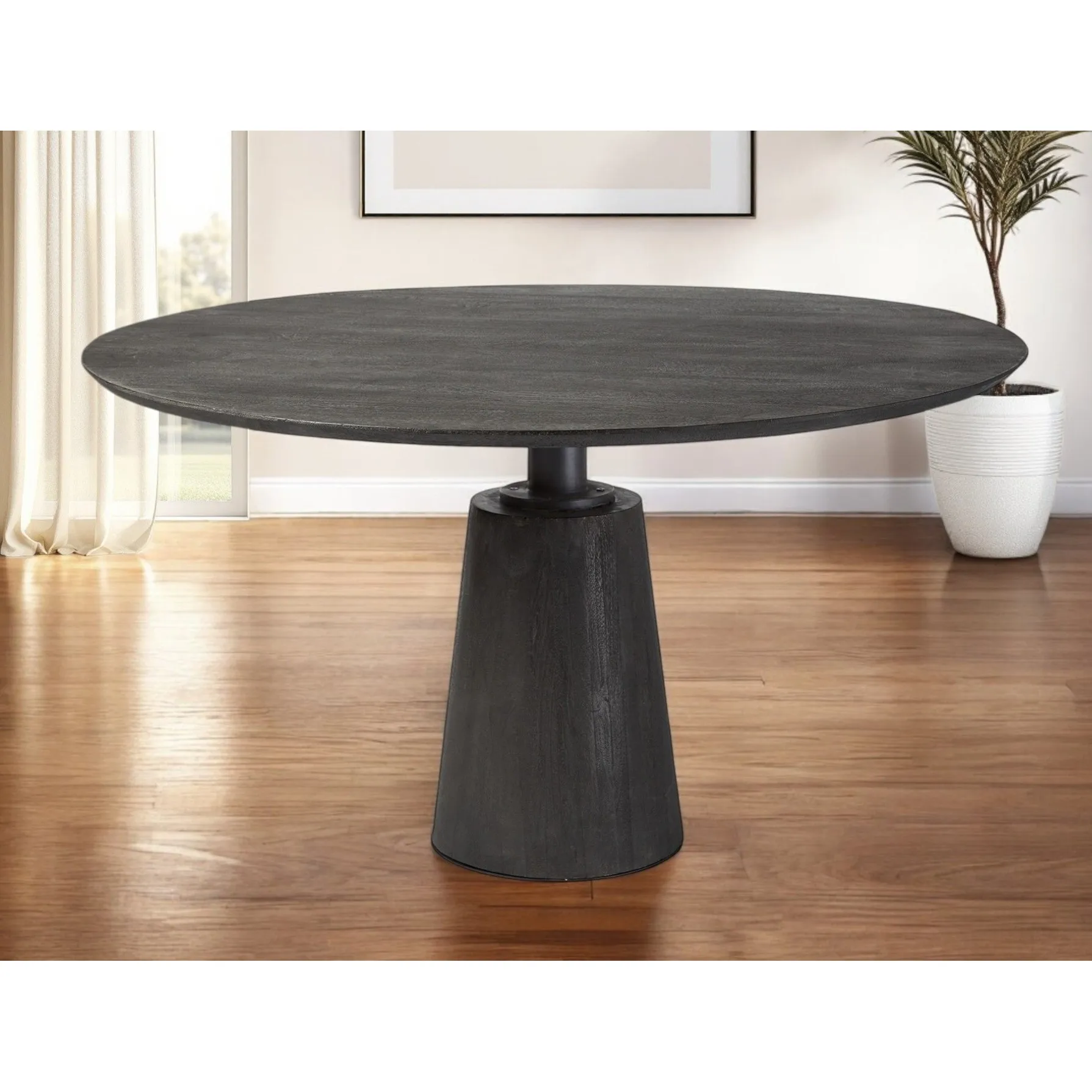 Brown solid wood dining table with metal pedestal base in a modern dining room