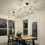 Industrial retro black spider chandelier with 8 adjustable arms and bulb sockets, hanging from ceiling in a living room