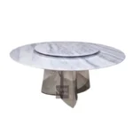 Modern marble round dining table with sintered stone top and titanium gold stainless steel base in a stylish dining room setting.