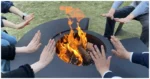 Outdoor fire pit chimnea on patio with flames and grill grate