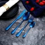 Elegant gold flatware set with fork, knife, and spoon on a white tablecloth
