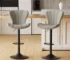 Modern bar stool with sleek black frame and cushioned seat in a luxury home gym setting