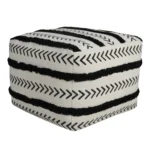White striped storage ottoman in living room with books and decor on top