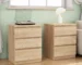 Set of two handle free nightstands with three drawers each, natural wood finish, in a modern bedroom