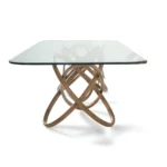 Large rectangular dining table with clear glass top and solid wood pedestal base in a bright dining room