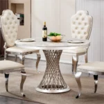 47-inch round marble dining table with stainless steel base in a modern luxury dining room setting