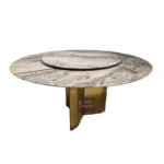Modern round dining table with white marble top and gold stainless steel base in a bright dining room