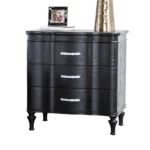 Black solid wood nightstand with curved front and turned legs in a bedroom setting