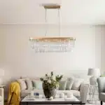 Side view of the adjustable chandelier with crystals layered on a rectangular frame, illuminating a modern living space.